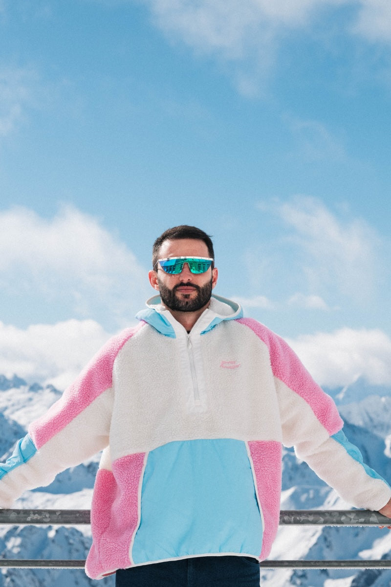 Person wearing a colorful jacket with mountains in the background